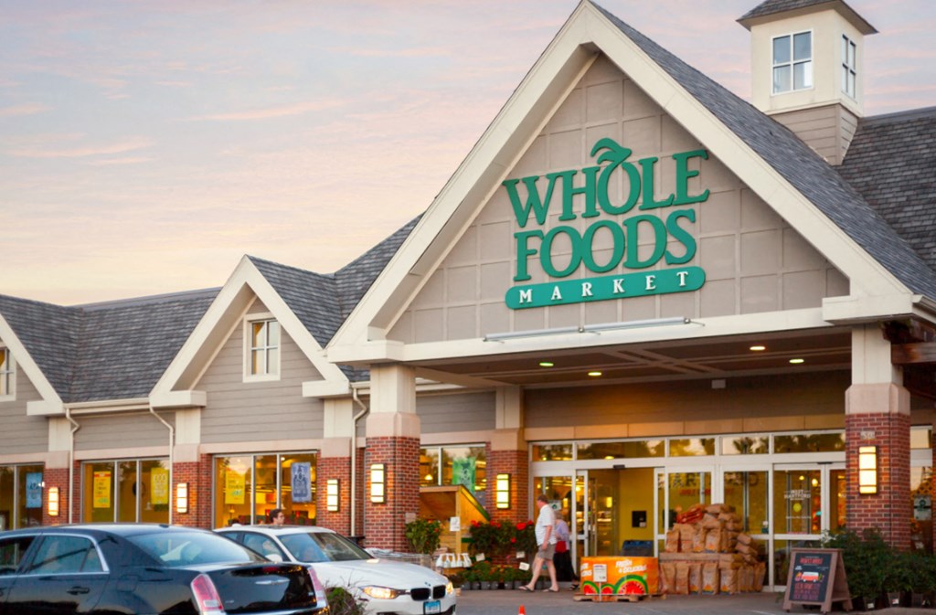 a whole foods market with cars parked outside