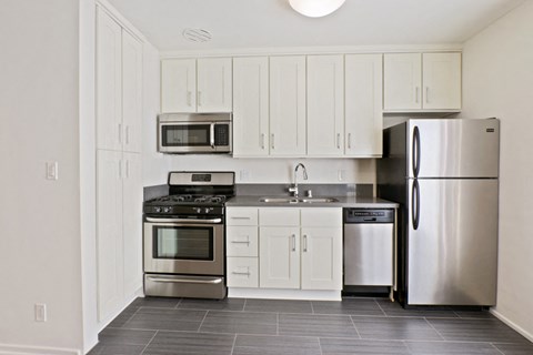 A kitchen with white cabinets and stainless steel appliances.