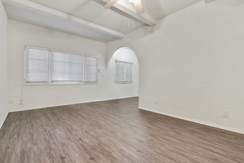 A room with wooden flooring and white walls.