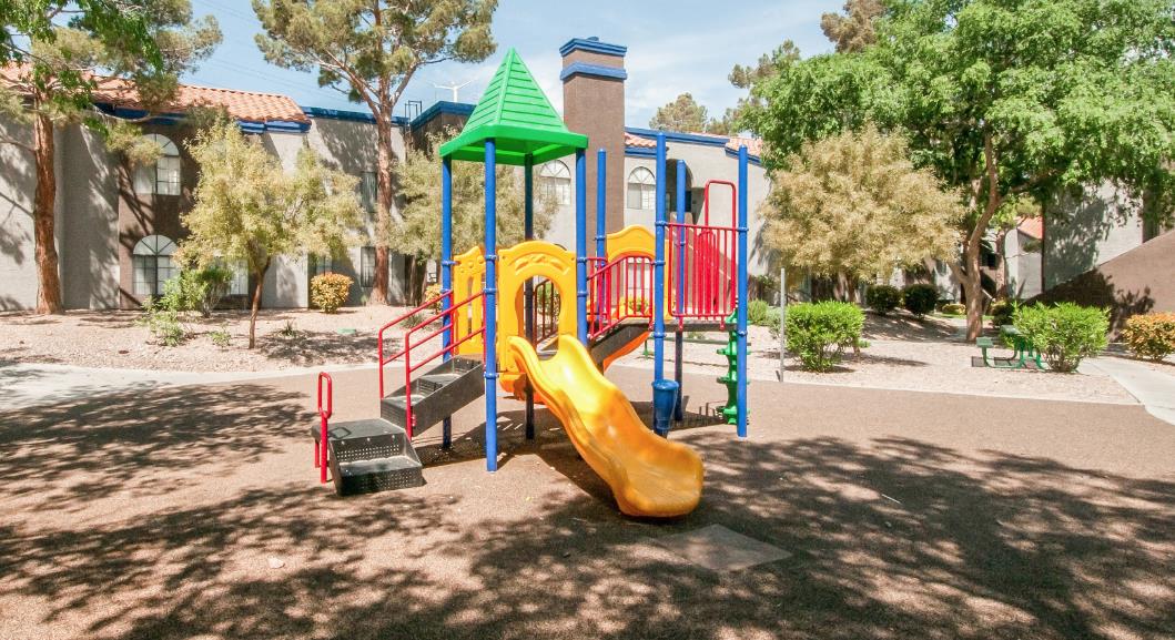 a playground with a yellow slide and other playground equipment