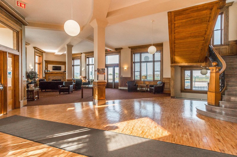 a large lobby with wood floors and a staircase
