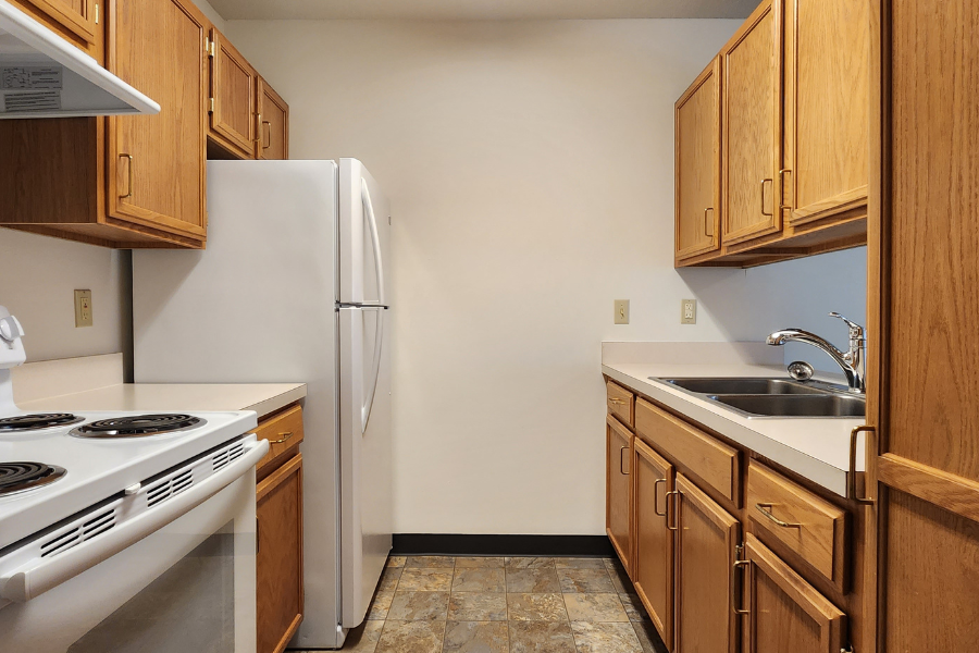 an empty kitchen with a stove refrigerator and sink