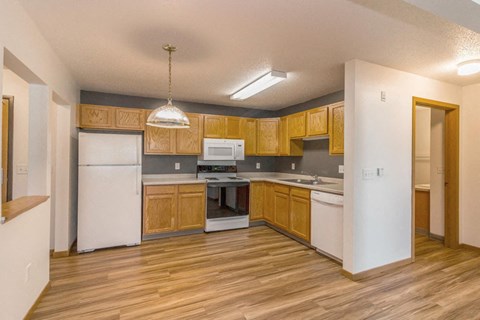 a kitchen with wooden cabinets and white appliances
