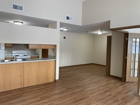 an empty living room and kitchen with a wood floor