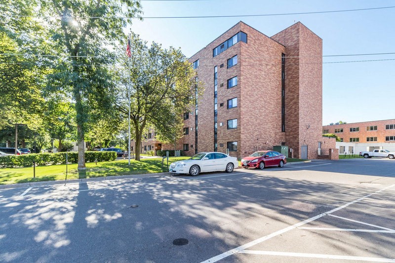 a large brick building with cars parked in a parking lot