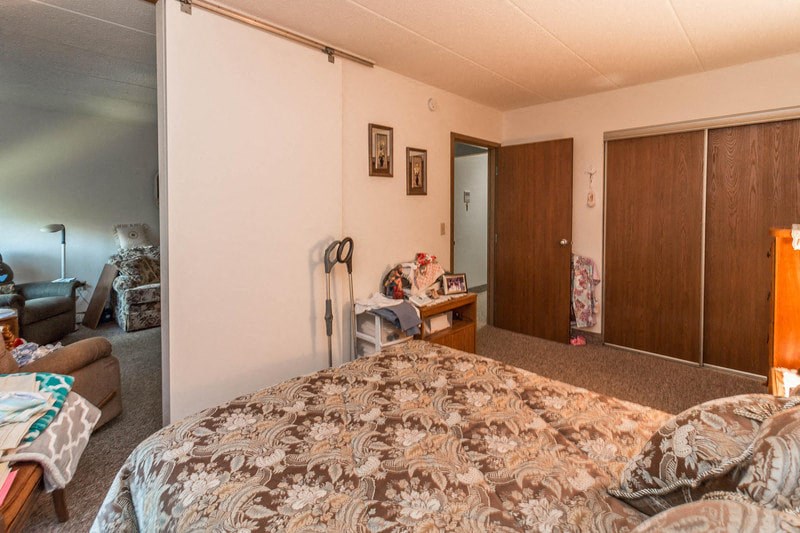 a bedroom with a bed and a desk and a closet