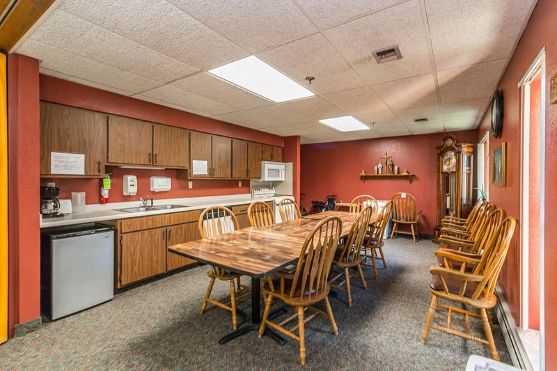 a conference room with a table and chairs and a kitchen
