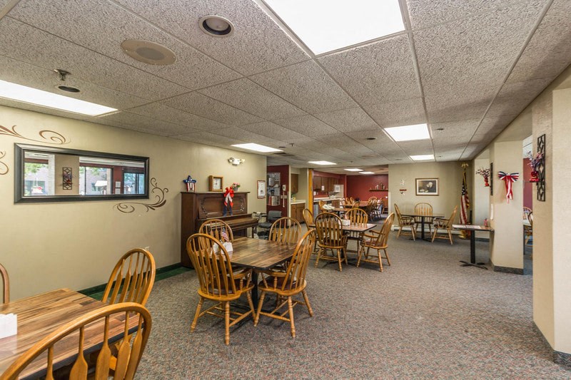 a dining room with wooden tables and chairs in a building