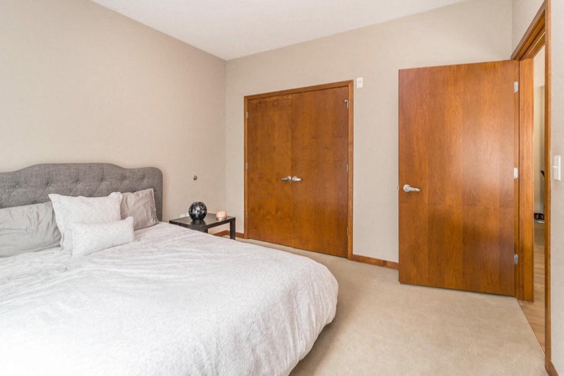 a bedroom with a bed and a closet and a door