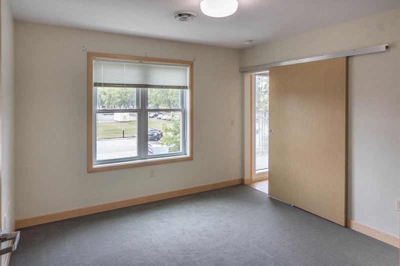 an empty living room with a window and a door