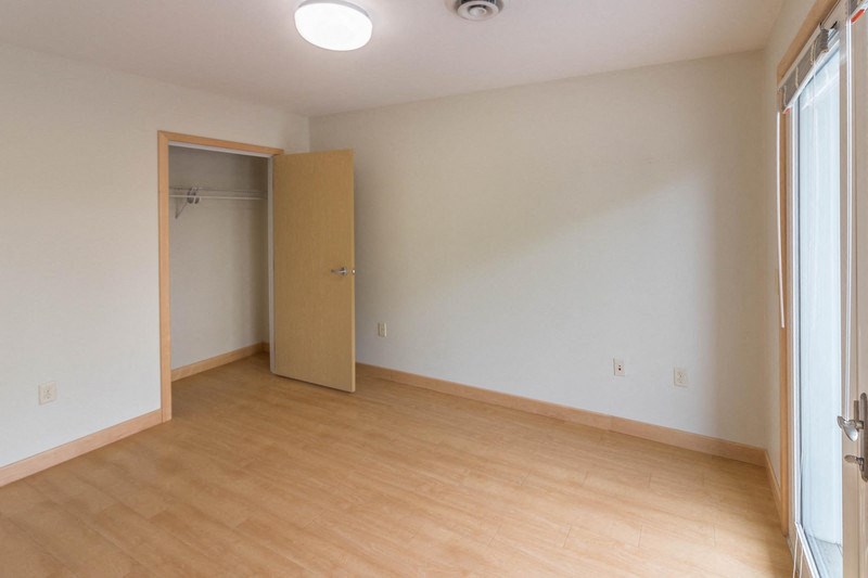 an empty living room with a door to a closet