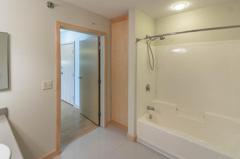 a white bathroom with a shower and a sink