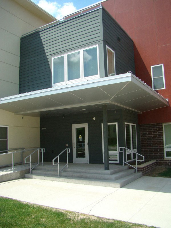the front of a building with stairs and a door