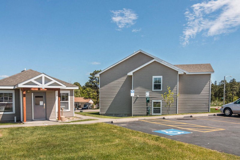 the front of a house with a parking lot and a driveway