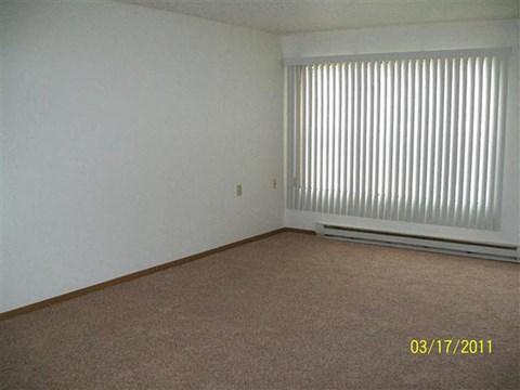 a living room with a large window and a carpet