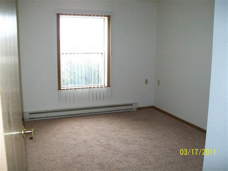an empty room with a window and a door