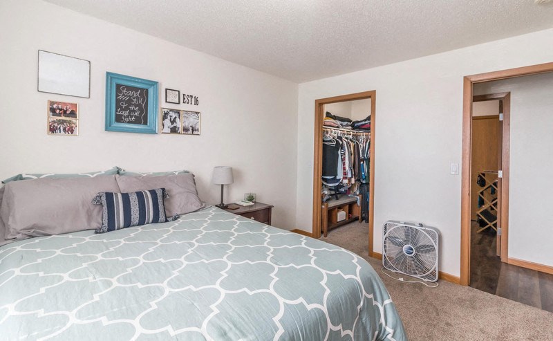 a bedroom with a bed and a closet with a fan