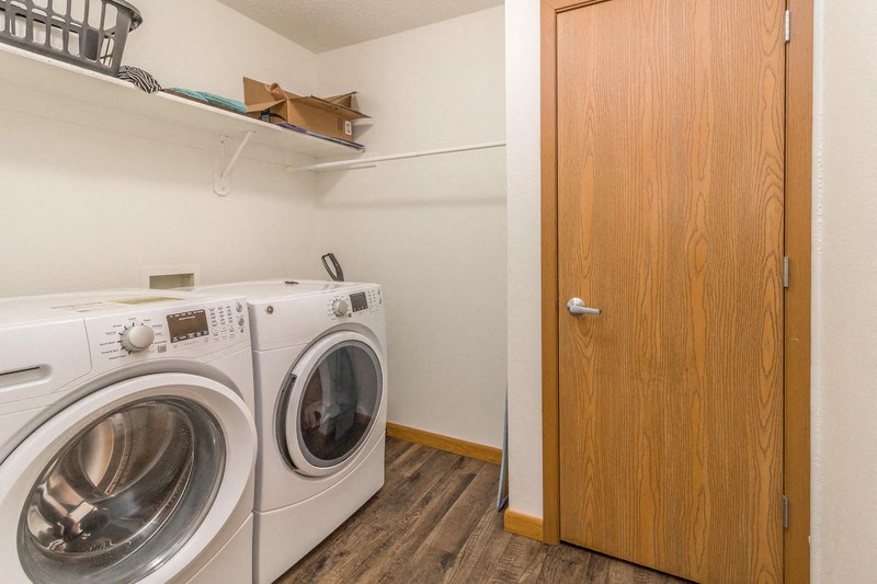 a washer and dryer in a laundry room with a wooden door