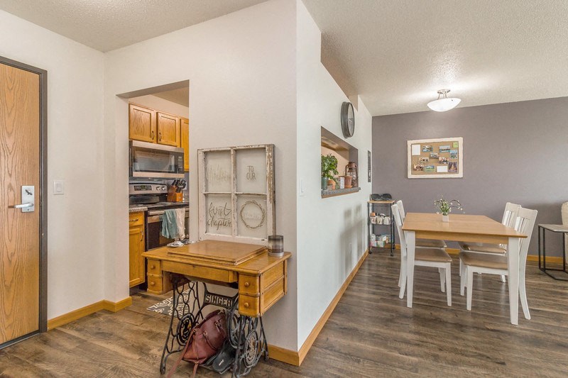 a dining room and kitchen with a wooden table and chairs