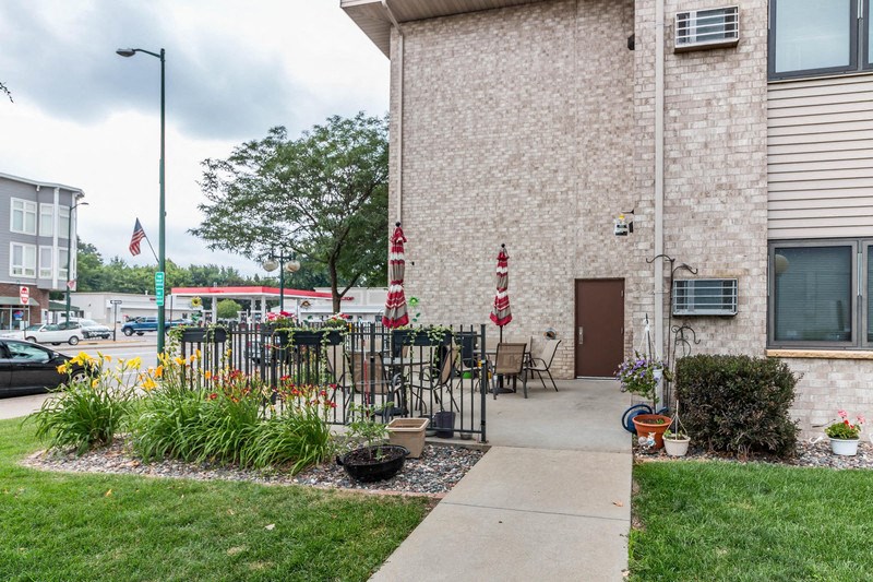 the outside of a building with tables and chairs and a sidewalk