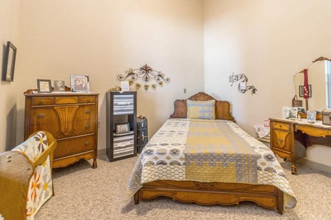 a bedroom with a bed and a dresser and other furniture