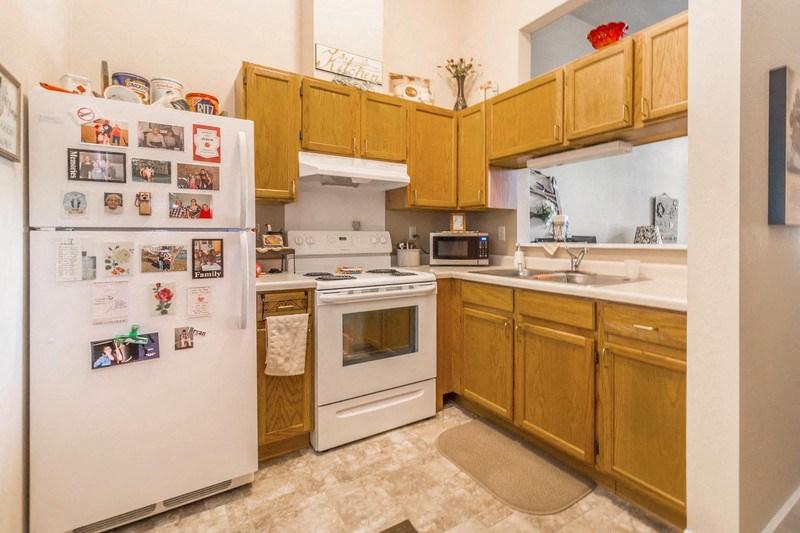 a kitchen with white appliances and wooden cabinets
