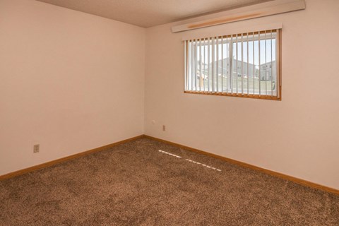 the living room of a home with a window and carpet