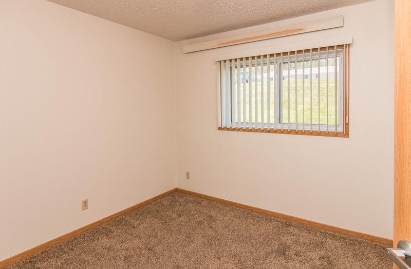 the living room of a home with a window and carpet