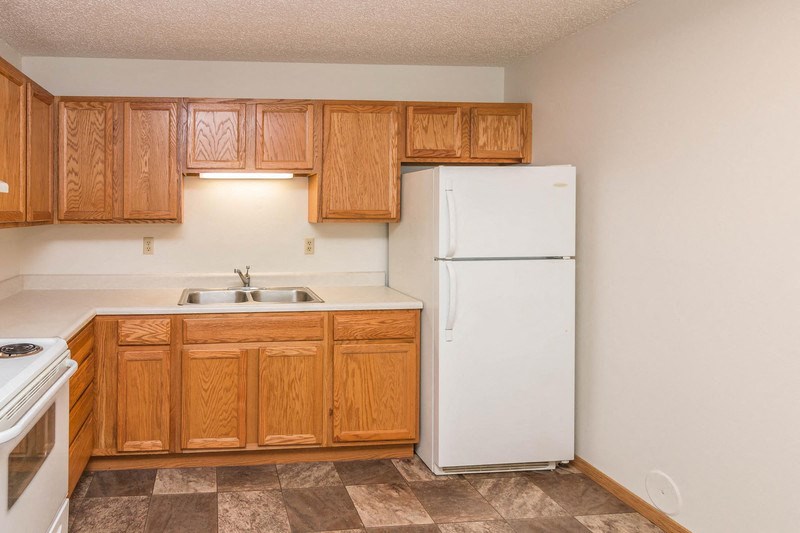 a kitchen with wooden cabinets and a white refrigerator