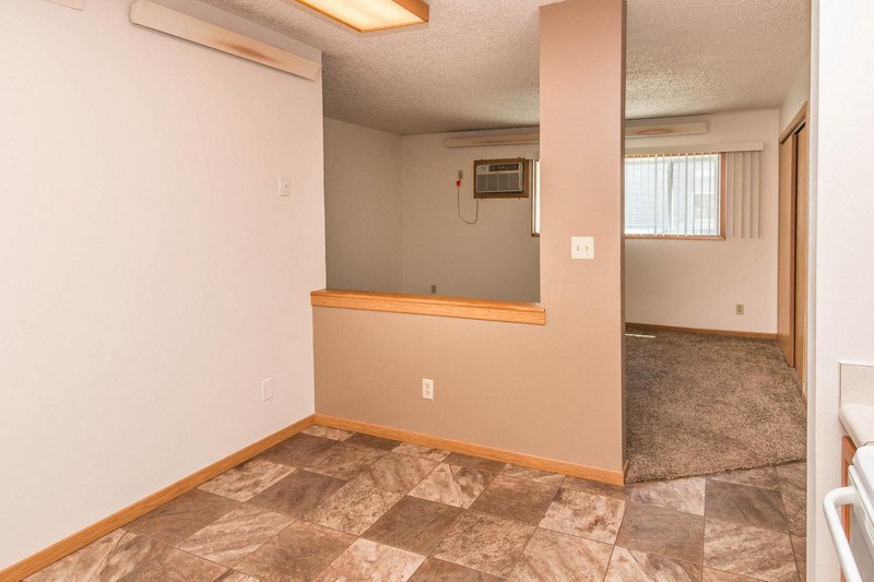 the living room and dining room of an empty house