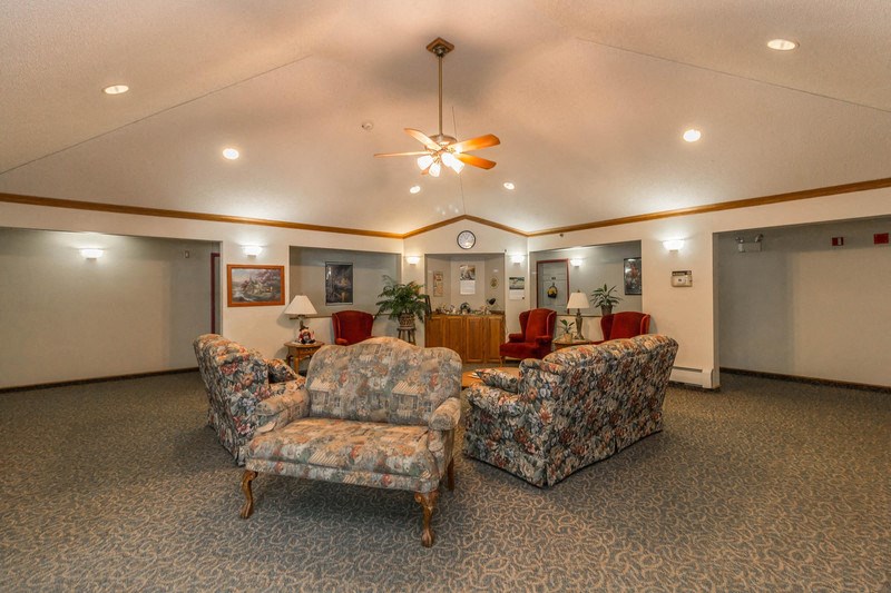 a lobby with couches and chairs and a ceiling fan