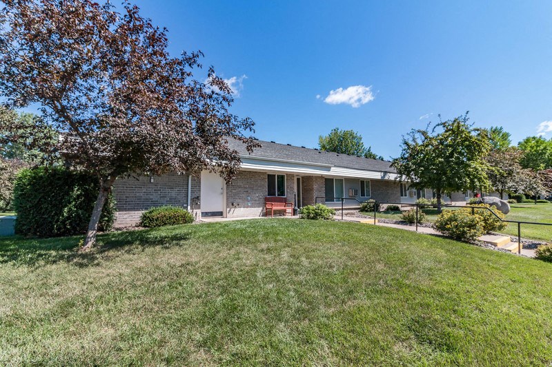 a brick house with a yard and a tree