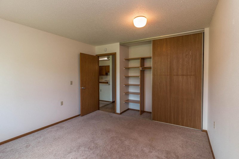 a bedroom with a closet and a door to a bathroom