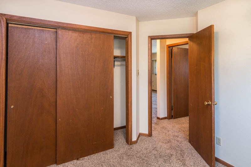a bedroom with three closets and a hallway with three doors