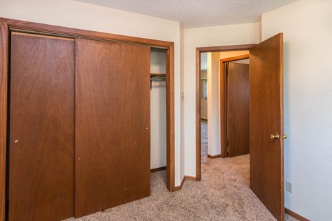 a bedroom with three closets and a hallway with three doors