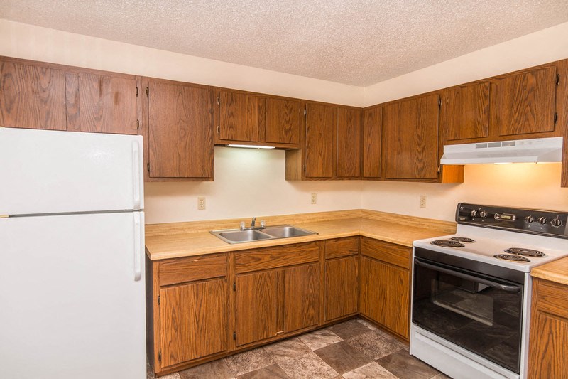 a kitchen with white appliances and wooden cabinets