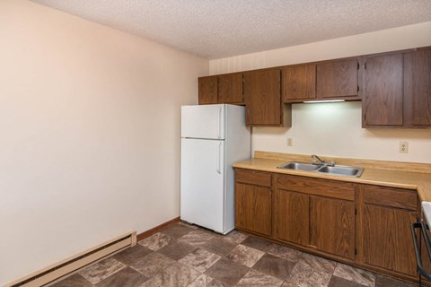 a kitchen with a white refrigerator and wooden cabinets