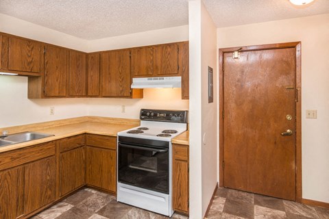 a kitchen with wooden cabinets and a stove and a refrigerator