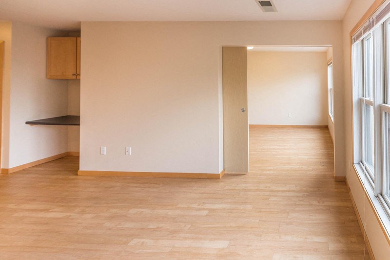 the living room and dining room of an empty house