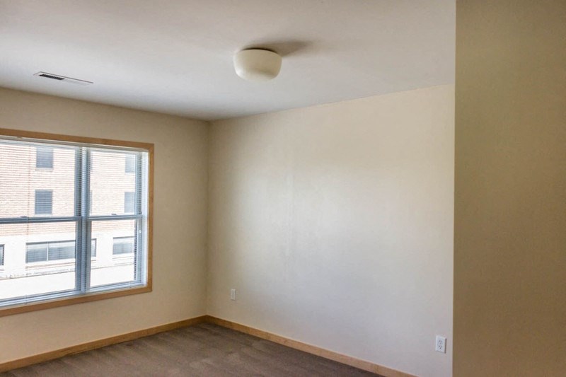 an empty room with a window and a white wall