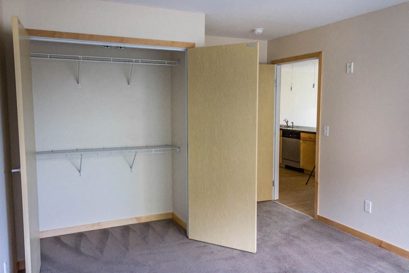 an empty room with a closet and a mirror in it