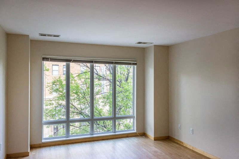 the living room of an empty house with a large window