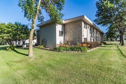A house with a lawn and trees in front of it.