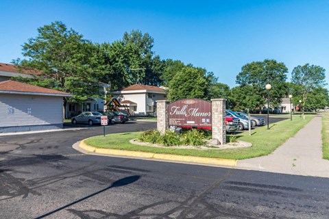 A sign for "Pillsbury Manor" stands in front of a parking lot.