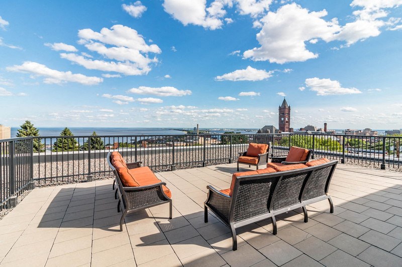 the view of the city from a rooftop terrace with tables and chairs
