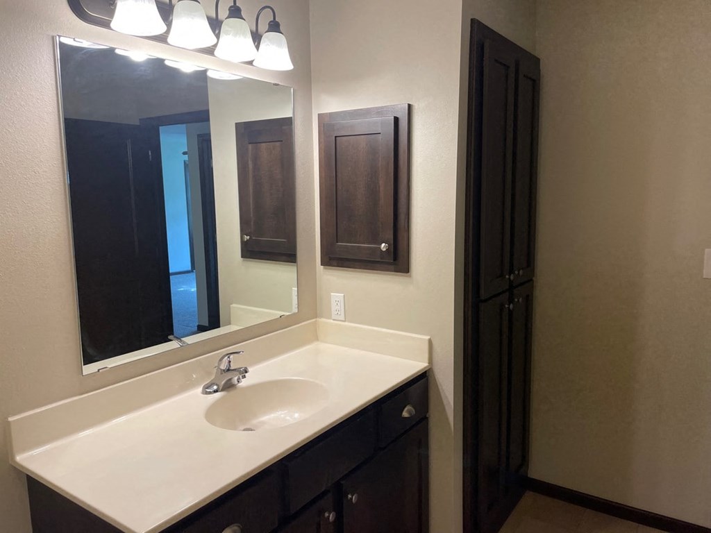 a bathroom with a sink and a mirror and a door