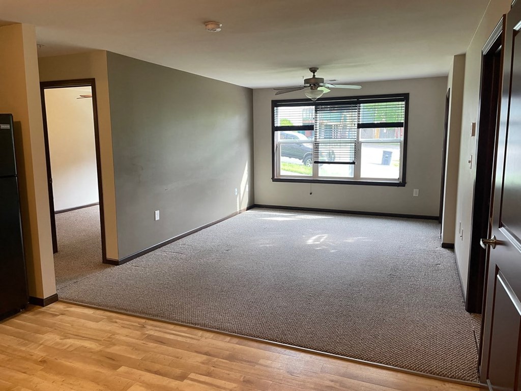 a empty room with a ceiling fan and a window