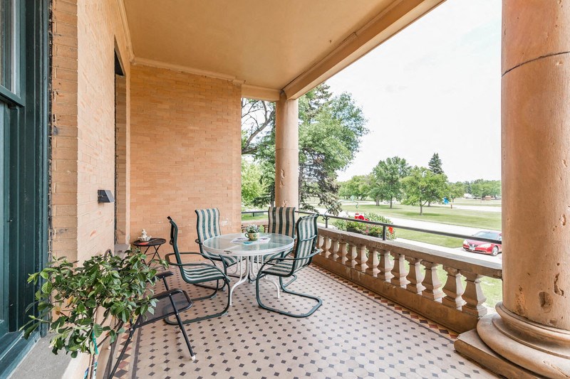a porch with a table and chairs on it