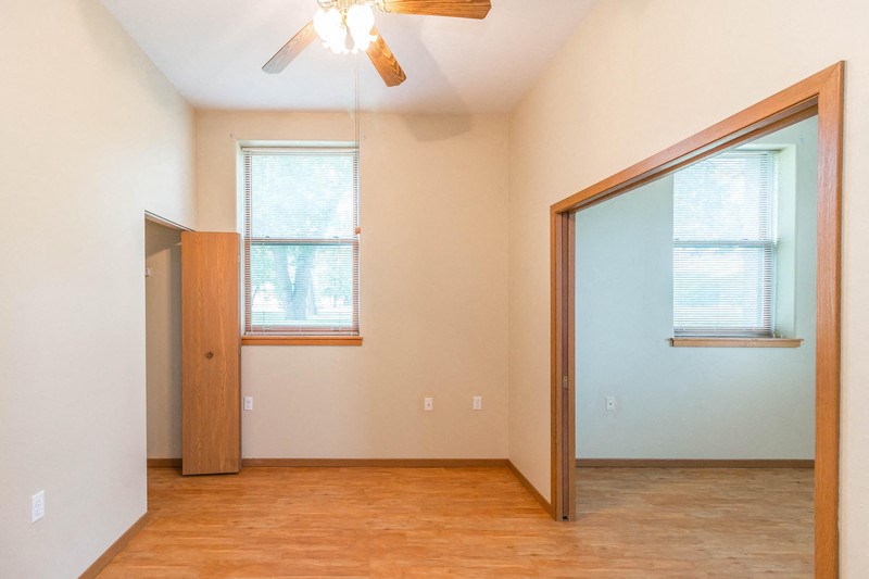 an empty room with a mirror and a ceiling fan