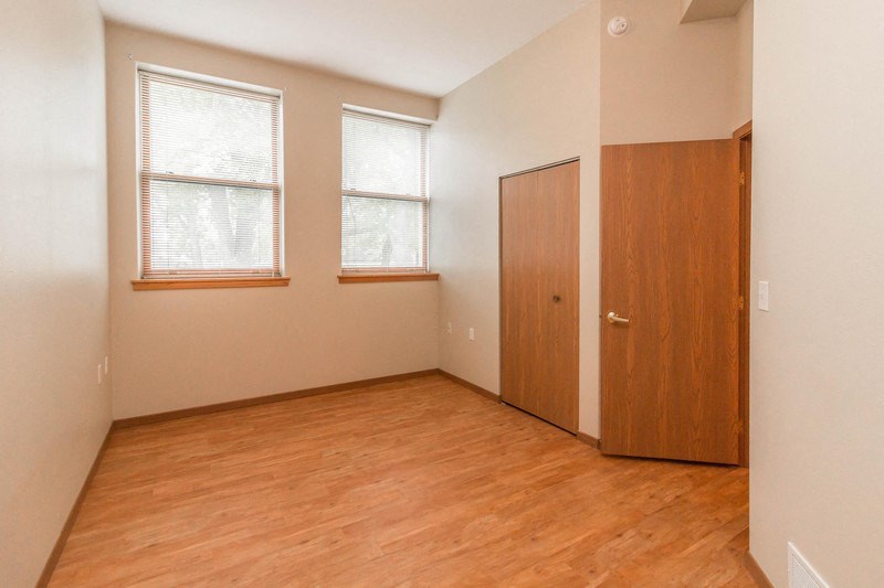 an empty room with a wooden floor and a door